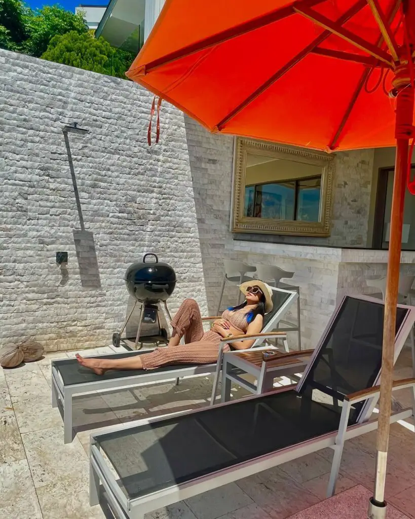 Sharkshe aka Shakshi Shetty enjoying the poolside while sitting on a ledge in a bikini.