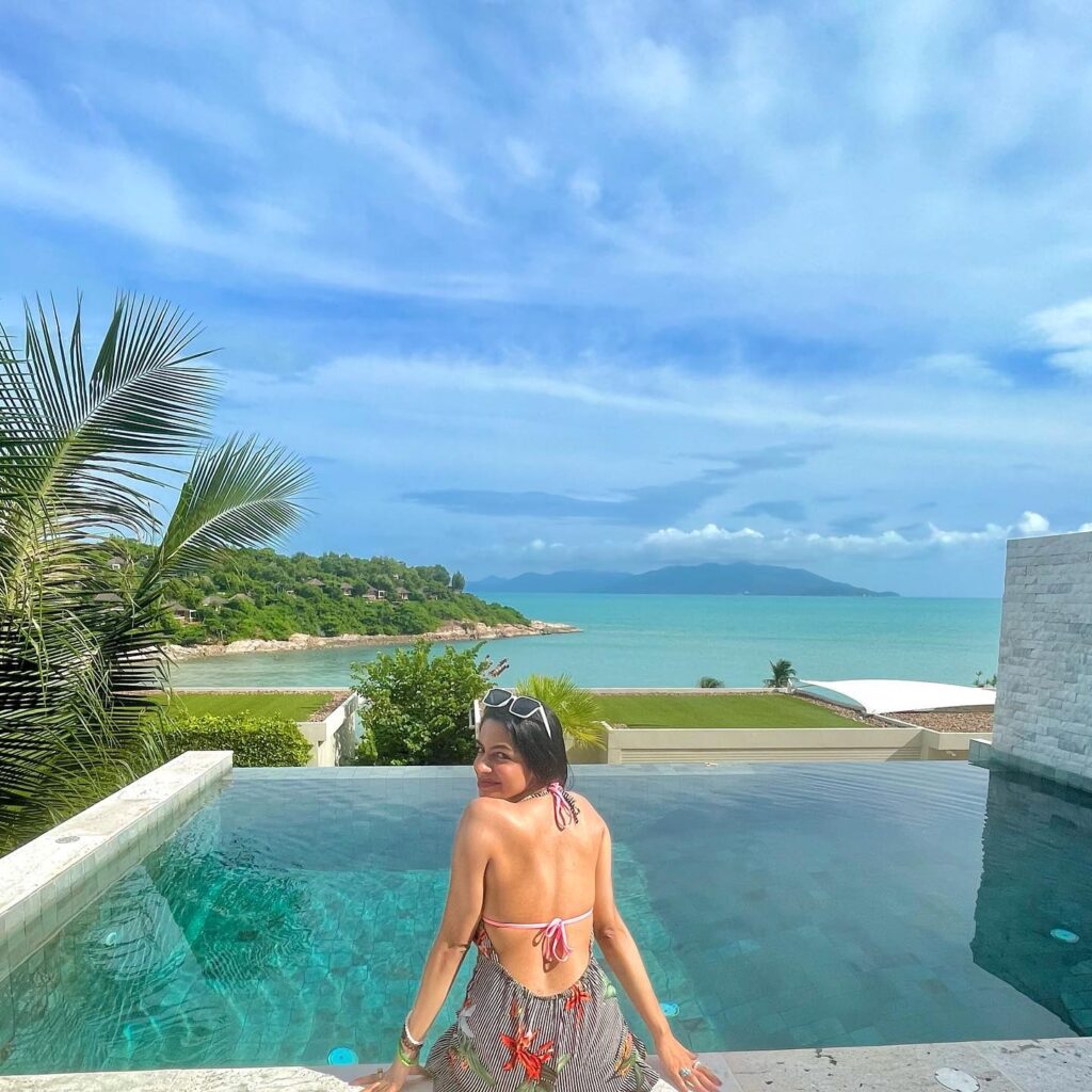 Sharkshe aka Shakshi Shetty enjoying the poolside while sitting on a ledge in a bikini.