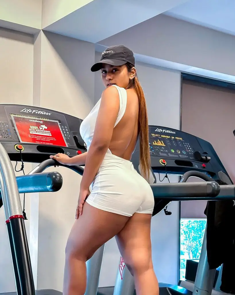 Suhana Khan, aka Suhuuu, in a white dress and hat, engaging in a workout on a treadmill